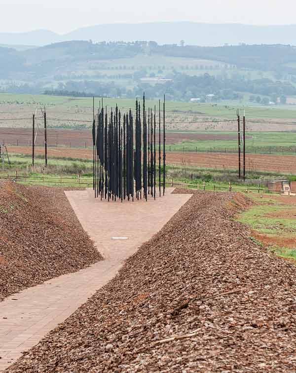 Approaching mandela sculpture along paved path